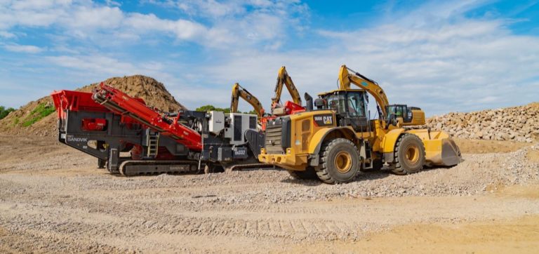 Wheel loader and mobile rock crusher among material stockpiles at Applied Materials Logistics.