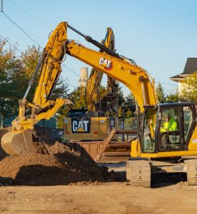 Several excavators working around soil piles at the Waterhouse redevelopment site.
